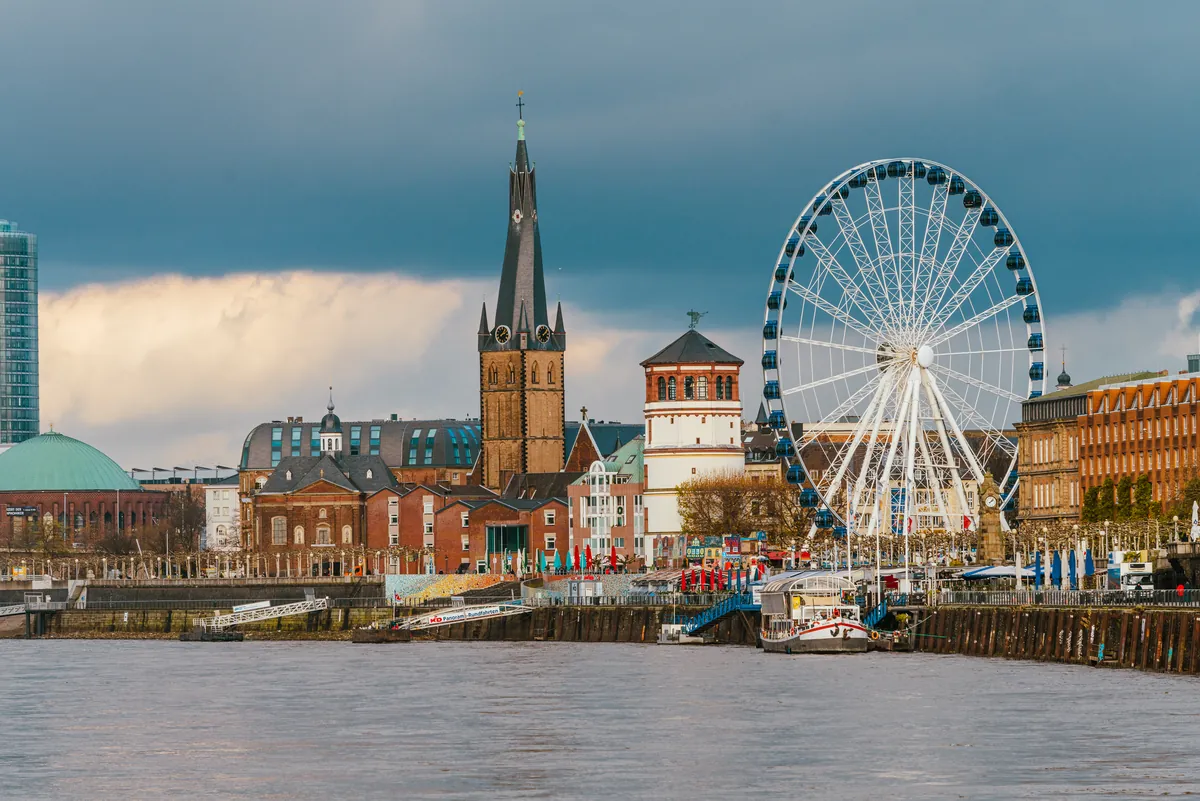 Düsseldorf’s old town on the Rhine with the spire of St Lambertus and the Castle Tower under a dramatic sky
