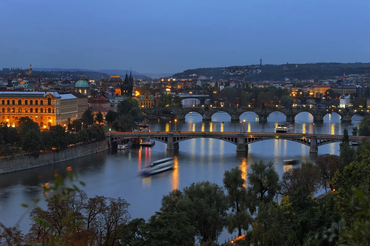 The Vltava in Prague at blue hour with its bridges, Charles Bridge among them, and the lights of the old town