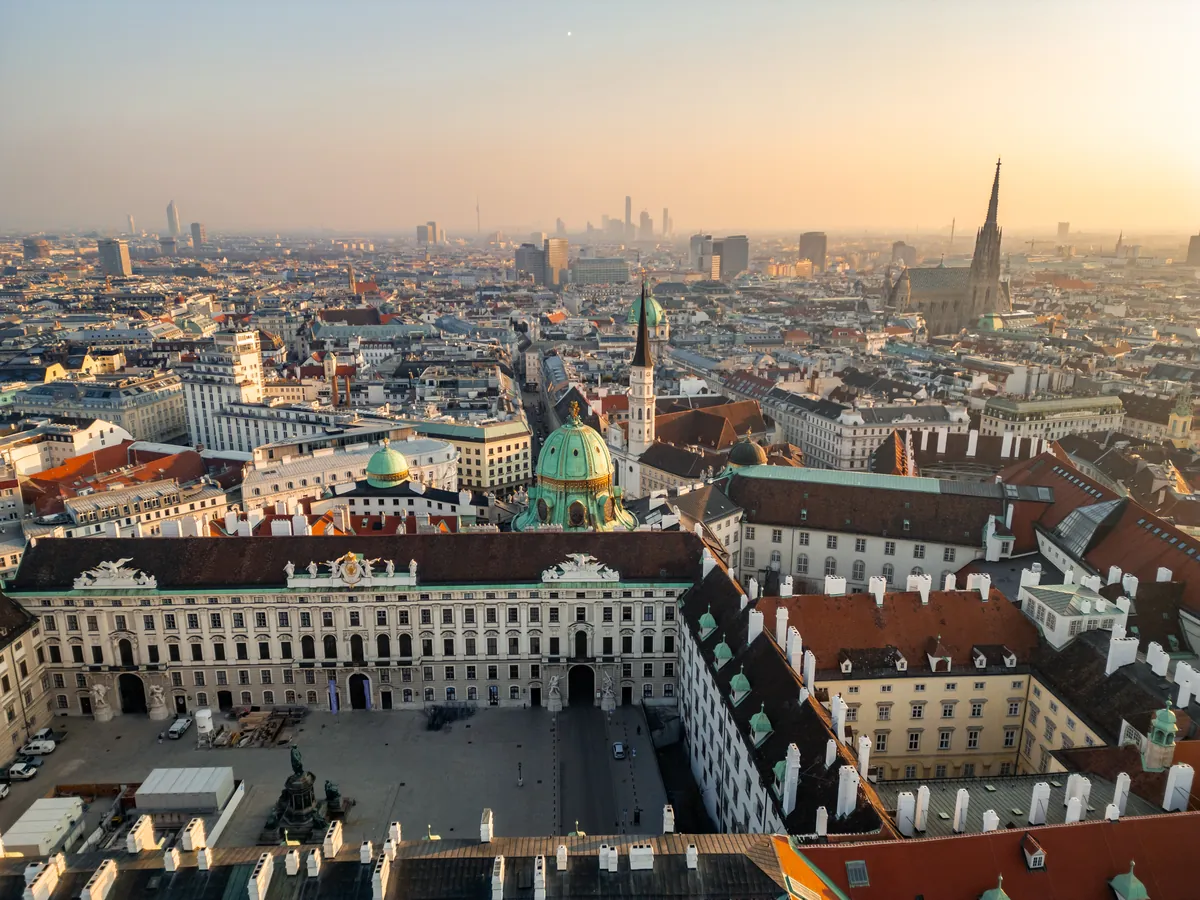 Vienna at sunrise seen from above, the Hofburg palace in front and St Stephen’s spire in the distance